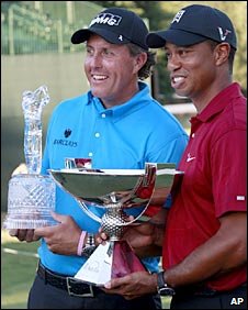 Phil Mickelson (left) holds the Tour Championship trophy while Tiger Woods holds the FedEx Cup