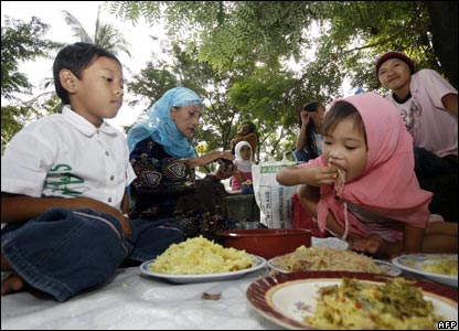 Filipino Muslim families enjoy their breakfast after early morning prayer celebrating Eid al-Fitr, at Rizal park in Manila 