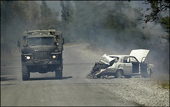 A Russian military truck passes by a wrecked Georgian car on the way from Tskhinvali to Gori, Georgia, Saturday, Aug. 16, 2008. Russian troops on Saturday were deployed in large numbers west of Igoeti, in and around the strategic city of Gori, which endured an intense Russian bombardment during the fighting that began when Georgia attacked the breakaway region of South Ossetia. (AP Photo/Dmitry Lovetsky)