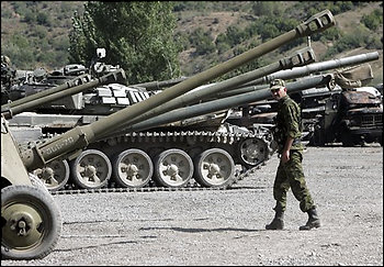 A Russian soldier inspects weapons seized from the Georgian military, in Tskhinvali, South Ossetia, Sunday, Aug. 17, 2008. Russian military authorities issued a flurry of conflicting reports Sunday about whether Russian troops had begun to pull out of South Ossetia, one of Georgia's two separatist provinces. (AP Photo/Sergey Grits)