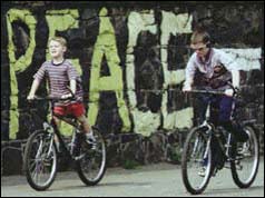 Children cycling by peace sign in Belfast