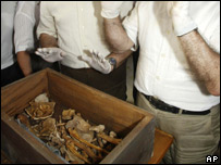 Scientists in front of a box containing the exhumed bones of two 15th century humanists 